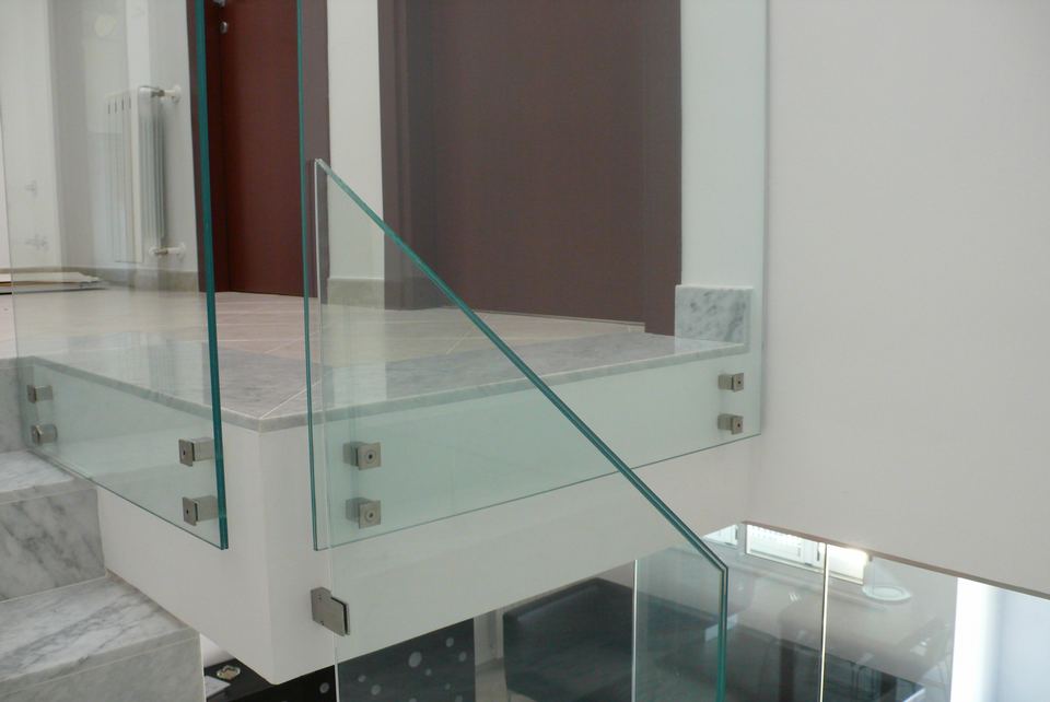 Pannelli in vetro stratificato temperato per scala interna in stile moderno.
Supporti quadrati reggi vetro in acciaio inox satinato.