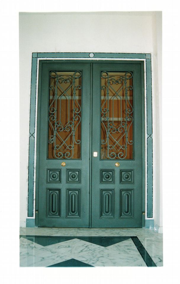 Porta a due ante in stile classico. Ante con decori in ferro battuto