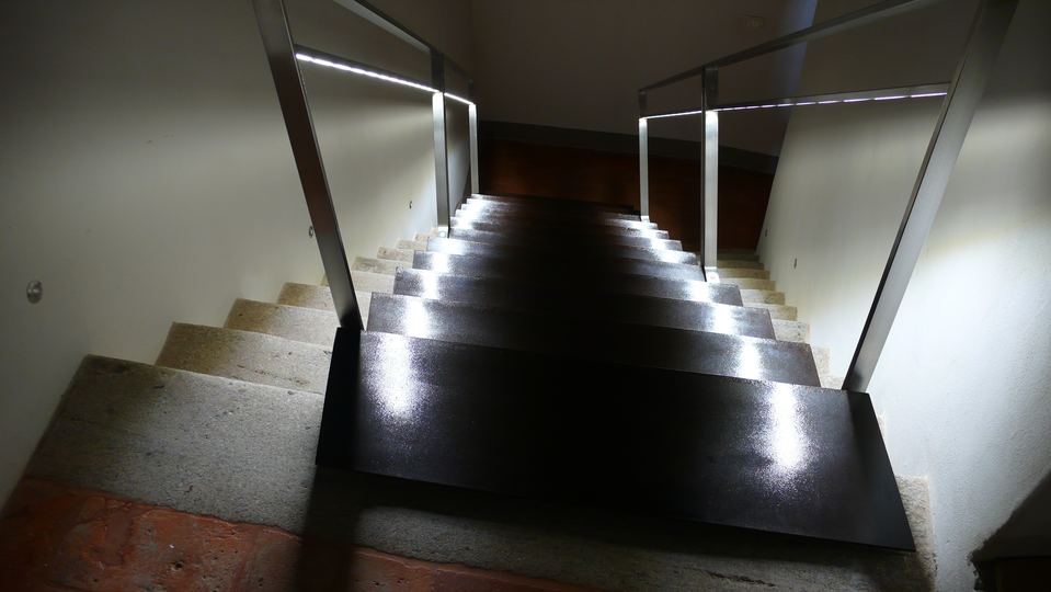 Particolare asole per inserimento luci a led su scala in lamiera ossidata e ringhiera in acciaio inox satinata.